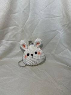 a small crocheted animal keychain on a white cloth covered tablecloth