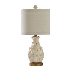 a white lamp with a beige shade on it's base and a light bulb in the middle