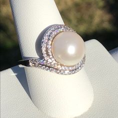 Genuine Freshwater Pearl Silvertone Ring Surrounded By Two Rows Of Simulated Diamond Which Are White Faceted Cz's 1.13 Cts, 96 Count. Nwot Only Reasonable Offers Will Be Considered And Are Encouraged White Pearl Rings With Diamond Accents, Elegant Diamond White Rings With Rhinestones, Diamond White Pearl Ring With Diamond, White Pearl Ring With Diamond Accents, White Rhinestone Promise Ring, Elegant White Sparkling Rings, Classic White Cubic Zirconia Pearl Ring, White Sparkling Pearl Jewelry, Dazzling White Rings With Rhinestones