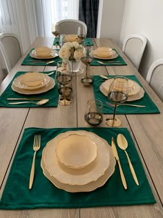 the table is set with dishes and place settings for four to six people, along with silverware