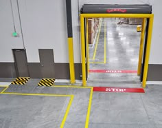 an empty parking garage with yellow and red barriers