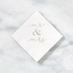 a white napkin with the word mr and mrs printed on it sitting on a marble surface