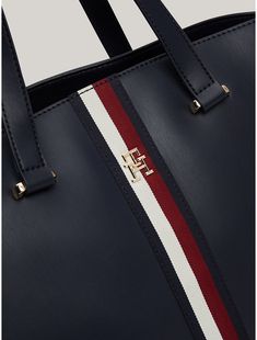 Tommy Hilfiger women's bag. Signature branding and gold-tone hardware set the tone of this sophisticated tote bag, complete with dual carry handles for comfortable toting. It also features side zips and an expandable lining to change its shape and add room to the main compartment.  Material: 100% Polyurethane. Elegant Tommy Hilfiger Leather Shoulder Bag, Tommy Hilfiger Leather Shoulder Bag For Daily Use, Elegant Tommy Hilfiger Shoulder Bag For Travel, Elegant Tommy Hilfiger Leather Bag, Tommy Hilfiger Rectangular Leather Bag, Chic Tommy Hilfiger Rectangular Bag, Classic Tommy Hilfiger Everyday Bag, Chic Tommy Hilfiger Shoulder Bag, Chic Tommy Hilfiger Leather Bags