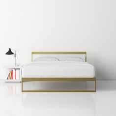 a white bed sitting next to a book shelf