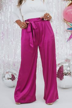 Unveil elegance with our "Best For Last" Satin Pants in Magenta. These luxurious pants exude sophistication with their smooth satin finish and vibrant magenta hue. Perfect for making a bold fashion statement at special events or elevating your everyday style. Date Night outfit inspo Waistband: High rise Fabric: 95% Polyester, 5% Spandex Sleek satin fabrication Adjustable tie belt waistband Wide leg bottom Imported Fit: True to size!- Waist: Elastic/High rise- Leg: Wide leg - Stretch only in wais Pink Satin Evening Bottoms, Spring Pink Satin Bottoms, Chic Pink Satin Bottoms, Elegant Pink Satin Bottoms, Pink Stretch Satin Bottoms, Solid Satin Party Pants, Elegant Full-length Purple Bottoms, Elegant Full Length Purple Bottoms, Elegant Purple Satin Bottoms