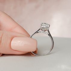 a woman's hand holding a diamond ring