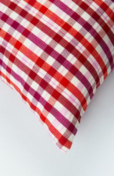 a red and white checkered pillow sitting on top of a table