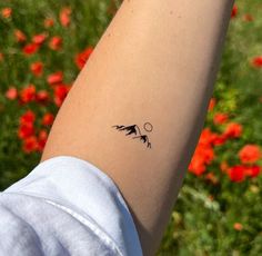 a woman's arm with a small tattoo on it