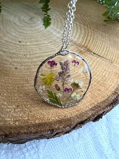 Handmade Epoxy resin necklace with real dried flowers. Made in the UK. Perfect and unusual gift idea. Comes beautifully presented in a gift box. Pendant material - alloy, hypoallergenic. Chain material:  sterling silver, silver plated, lightweight.  Stay close to nature with this necklace. Perfect happy summer necklace with bright colours flowers. Perfect anniversary, birthday or leaving gift.  Clover flower The meaning and symbolism of clover flowers are closely associated with good fortune and Clear Flower Pendant Necklace As Gift, Botanical Style Round Necklaces For Gift, Handmade Flower Necklace Gift, Dainty Necklace With Natural Inclusions For Gifting, Flower Shaped Pressed Flowers Jewelry For Mom, Botanical Round Necklace For Gift, Round Pendant Flower Necklace As Gift For Her, Unique Birth Flower Necklace Gift, Gift Clear Jewelry With Flower Charm