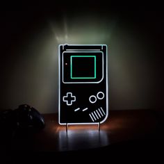 a lit up nintendo gameboy lamp sitting on top of a table