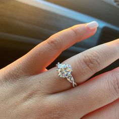 a woman's hand with a diamond ring on her finger, in the car