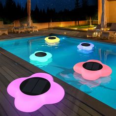 an inflatable pool is lit up at night with lights on the ground and chairs around it