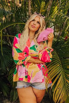 - Meet up with the girls in this adorable top! - Unlined material with a colorful abstract print and a satin finish - A v-cut neckline with ruffle detail - Faux button closure accents - ¾ length sleeves with elastic ruffle cuffs - A relaxed silhouette that ends in a straight hemline Pink Printed V-neck Blouse, Trendy Blouse With Abstract Print For Vacation, Trendy Vacation Blouse With Abstract Print, Chic Blouse With Abstract Print For Vacation, Chic Abstract Print Blouse For Vacation, Chic Vacation Blouse With Abstract Print, Trendy Abstract Print Blouse For Beach, Trendy Beach Blouse With Abstract Print, Pink Floral Print Trendy Blouse