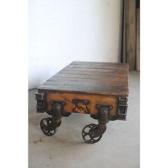 an old wooden table with wheels on it