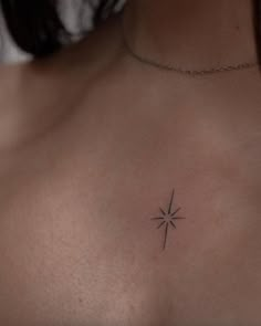 a woman's chest with a small star tattoo on the left side of her chest