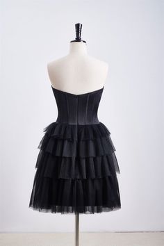 This dress features a corset bodice and a tiered ruffle skirt, with a sweetheart neck and zip-up back. Made from black tulle, it has an A-line silhouette and falls above the knee. Item #NP1112 Material: Tulle Color: Black Silhouette: A-line Embellishment: Corset bodice, tiered ruffle skirt Neck: Sweetheart neck Back: Zip-up Length: Above knee length Fully lined: Yes Built-in bra: Yes True to size. Made in China. Dresses are usually packed inside out for protection. Hand wash Tiered Ruffle Skirt, Corset Bodice, Short Homecoming Dress, Homecoming Dresses Black, Black Tulle, Black Silhouette, Ruffle Shorts, Sweetheart Neck, Homecoming Dress