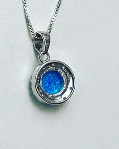 "Blue Opal Halo Necklace Minimalist and Dainty Necklace Metal: All components are made from solid .925 Sterling Silver Stone: 8mm Lab Created Opal; Cubic Zirconia Measurement: Pendant Height is 19mm (0.75\") including bail and 13mm (0.51\") wide Choose Chain Length Please feel free to Convo me with any questions before purchasing. Please view policy before purchasing Other Opal Necklaces can be found here https://www.etsy.com/shop/LinksAndStones?ref=ss_profile&section_id=24284450 Thank You F Silver Pendant Birthstone Necklace For Wedding, Silver Round Birthstone Necklace For Wedding, Blue Round Pendant Necklace For Formal Occasions, White Gold Sterling Silver Birthstone Necklace For Wedding, Formal Blue Round Pendant Necklace, Silver Round Pendant Birthstone Necklace, Silver Pendant Birthstone Necklace With Bezel Setting, Silver Birthstone Pendant Necklace With Bezel Setting, Silver Birthstone Necklace With Round Pendant