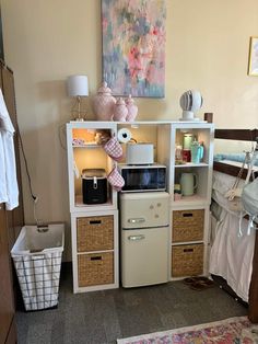 a small kitchenette in the corner of a room with drawers and baskets on it