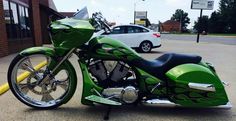 a green motorcycle parked in front of a building