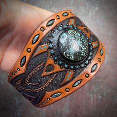 "\"The wheel of time\" is a hand tooled and hand painted leather cuff bracelet with natural turquoise gemstone. It would become a nice accessory for a modern Valkyrie. The item is almost ready to ship and will be delivered to you by registered airmail service once finalized. It just misses a snap button, which will be added in accordance with buyer's preferences. The size of the cuff can be finalized to fit a wrist size up to 7 1/4\" (~19 cm). Let me know the chosen size upon checkout. The cuff Handmade Turquoise Jewelry, Leather Gifts For Her, Handmade Boho Jewelry, Leather Ring, Hand Painted Leather, Hand Tooled Leather, Painting Leather, Leather Cuffs Bracelet, Leather Gifts