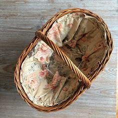 two wicker baskets sitting on top of a wooden floor next to each other with floral fabric coverings