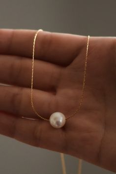 Dainty and minimal, pearl necklace. Designed with the skinniest chain that creates a modern and simple statement. This single necklace is tarnish free and meant to last with the proper love and care. Gold dipped chain and shiny, rounded, pearl. Luxury Dainty Pearl Drop Necklace, Cheap Minimalist Necklace With Round Beads, Cheap Everyday Pearl Pendant Jewelry, Luxury Minimalist Single Strand Pearl Necklace, Affordable White Pearl Necklace With Round Pendant, Pearl Necklace Outfit, Single Necklace, Single Pearl Necklace, Necklace Outfit