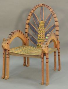 a chair made out of wood and painted with yellow, blue, and green designs