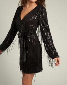 This Sequin Fringe Mini Dress features an eye-catching design with a unique blend of sequins throughout the fabric. Crafted with long fringes and a flattering fit, it's perfect for any special occasion. With a lightweight and comfortable feel, you'll look and feel your best. Model is 5’8” and is wearing a small 50% Pet 45% Polyester 5% Spandex lining: 100% Polyester Black Sequin Fringe Dress, Black Long Sleeve Dress With Rhinestone Fringe, Black Long Sleeve Mini Dress With Rhinestone Fringe, V-neck Party Dresses With Rhinestone Fringe, Evening V-neck Mini Dress With Fringe, Fringe Mini Dress, Long Fringes, Black Color, Special Occasion