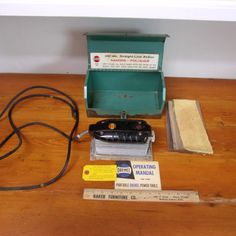 an electric sanding machine sitting on top of a wooden floor next to a box