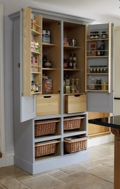 an open cabinet with baskets in it and shelves on the wall next to each other