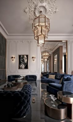 an elegant living room with blue velvet couches and chandelier hanging from the ceiling