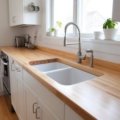 a kitchen with wooden counter tops and white cabinets