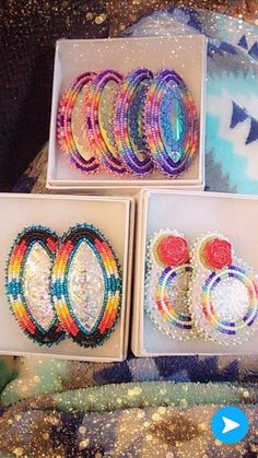 four different bracelets in boxes on a table