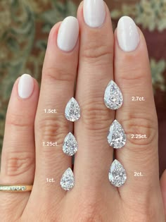 a woman's hand with five pear shaped diamonds on it and four smaller pear shaped diamonds in the middle