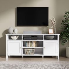 a white entertainment center with a flat screen tv mounted on it's sideboard