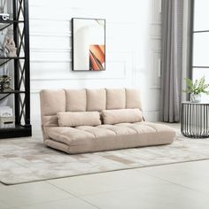 a living room with a couch, bookcase and rug on the floor in front of it