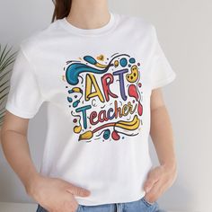 Introducing the perfect "Art Teacher Gift" - our "Best Art Teacher Shirt." This "Gift For Teacher" is ideal for any educator who loves to inspire creativity. The "Teacher Shirt" features a unique design, making it a standout "Art Tshirt" for any occasion. Whether you're looking for an "Artist T-Shirt" or an "Art Lover Tee," this "Art Shirt" is the ultimate "Teacher Gift." **Product Details - 100% Airlume combed and ringspun cotton (fiber content may vary for different colors) - Light fabric (4.2 White Custom Print Artistic Art, White Artistic Art With Custom Print, Artistic White Art With Custom Print, Artistic Graphic Print Tops As Gift, Artistic Graphic Print Top As Gift, Artistic Graphic Print Top As A Gift, Artistic White Tops With Custom Artwork, Artsy Tops With Sublimation Print And Short Sleeves, Artsy Cotton Tops With Sublimation Print