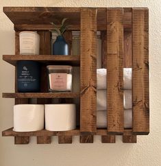 a wooden shelf with toiletries and candles on it