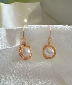 Experience the blend of traditional elegance and modern craftsmanship with our Handcrafted Wire-Wrapped Pearl Earrings. Each earring features a lustrous pearl encased in a delicate gold wire nest, offering a unique and stylish look. These earrings are perfect for those who appreciate the beauty of handcrafted jewelry and seek a versatile accessory that pairs well with both formal and casual outfits. Features: Material: High-quality pearl and gold-colored wire Design: Unique wire nest design arou Wire Design, Nest Design, Style Baroque, Earrings Elegant, Stunning Earrings, Pearl Studs, Elegant Earrings, Jewelry Lover, Minimalist Style