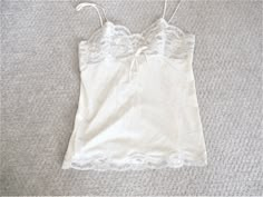 This vintage Formfit Rogers camisole top is a size 34. It measures 14.5 inches seam to seam under the bust laid flat and 25 inches from the top of the strap to the bottom of the lace. It is a pale pink with ivory floral lace on the bodice and scalloped lace on the hem.  The tag reads size 34 and 12 - 14, Made in U.S.A. Excellent condition with no flaws. Fitted Cream Camisole With Built-in Bra, Fitted Cream Tank Top With Built-in Bra, Cream Camisole With Built-in Bra And Spaghetti Straps, Fitted Cream Tank Top With Lace Trim, White Tank Camisole With Delicate Straps, White Camisole With Delicate Straps, Cream Camisole With Adjustable Spaghetti Straps, Fitted Beige Lace Top Camisole, Cream Camisole Top With Built-in Bra