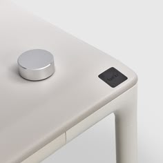 an electronic device sitting on top of a white table next to a metal object in the middle