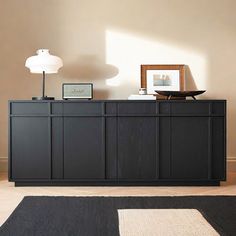 a living room with a black cabinet and white rug