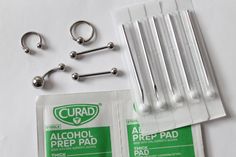 several different types of piercings are laid out on a white table with clear plastic bags