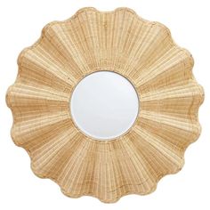 a round mirror made out of wicker on a white background with the reflection in it