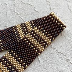 a close up of a tie made out of beads on a white surface with small holes in the middle