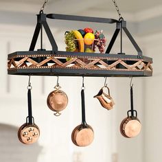 pots and pans hanging from a metal rack with wooden spoons on it's hooks