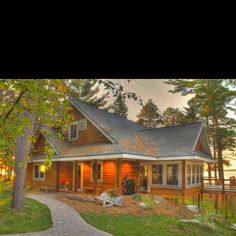 a log home with large front porch and covered patio area in the evening sun light