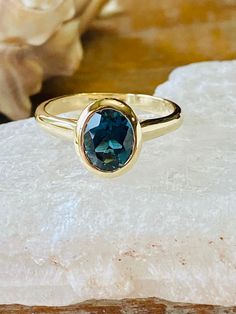 This bezel ring contains a 2.00 ct. natural London blue topaz. The center stone measures 8x6mm. The ring is available in sterling silver, and 14k white, yellow or rose gold. The mounting is a modern, elegant setting with a high polish finish. Please send me a message if you need a size not listed. This ring can also be customized with any color center stone. All items are handmade by me in my shop in Manalapan, NJ. Please message me with any questions. Shipping within the United States is compli Blue Oval Topaz Ring With Bezel Setting, Oval Blue Topaz Ring With Bezel Setting, Classic Oval Topaz Ring With Bezel Setting, Oval Topaz Ring With Bezel Setting For Anniversary, Blue Oval Ring With Bezel Setting, Sapphire Topaz Solitaire Ring, Oval Cut, Blue Oval Birthstone Ring With Bezel Setting, Bezel Set Engagement Ring, Buy Jewellery Online