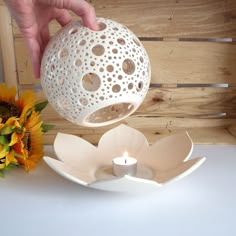 a person is pouring water into a vase with a flower on the table next to it