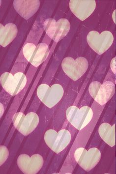 many hearts are arranged in the shape of small white hearts on pink and purple background